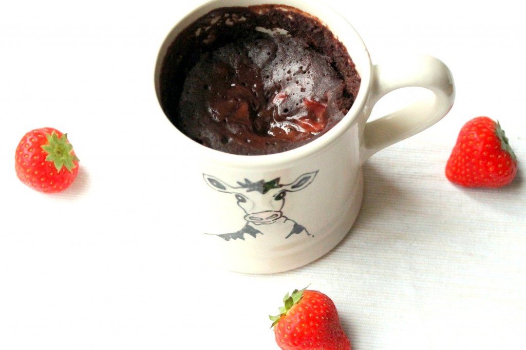 A decadent vegan dessert! Chocolate mug cake with a melting chocolate hazelnut and strawberry center. So easy and so yummy!