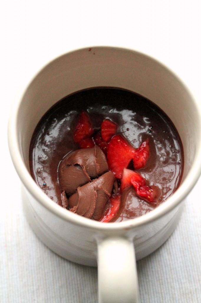 A decadent vegan dessert! Chocolate mug cake with a melting chocolate hazelnut and strawberry center. So easy and so yummy!