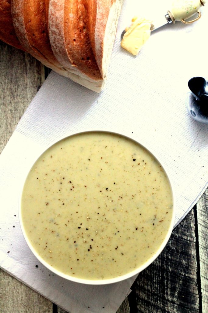 A top down view of of broccoli stilton soup with bread