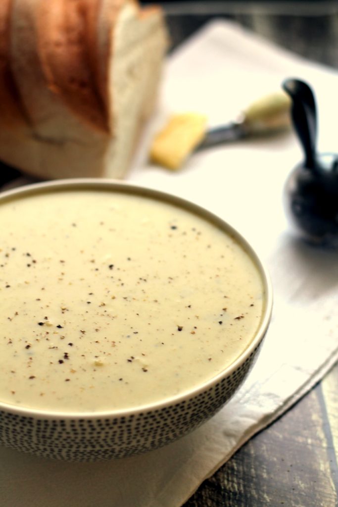 A bowl of broccoli stilton soup with bread