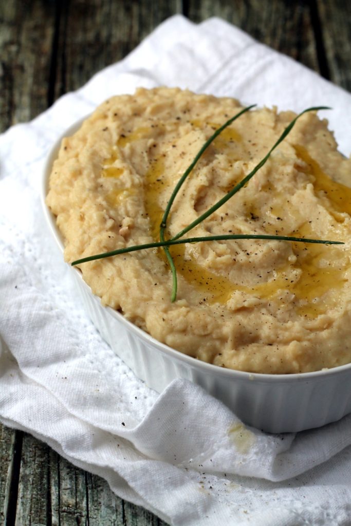A great healthy alternative to mashed potatoes, you won't believe how creamy and comforting white bean mash can be. This recipe is packed with roasted garlic and cheddar cheese for maximum flavor.