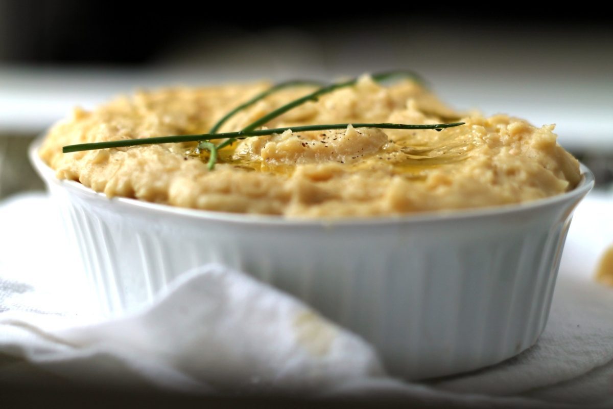 A great healthy alternative to mashed potatoes, you won't believe how creamy and comforting white bean mash can be. This recipe is packed with roasted garlic and cheddar cheese for maximum flavor.