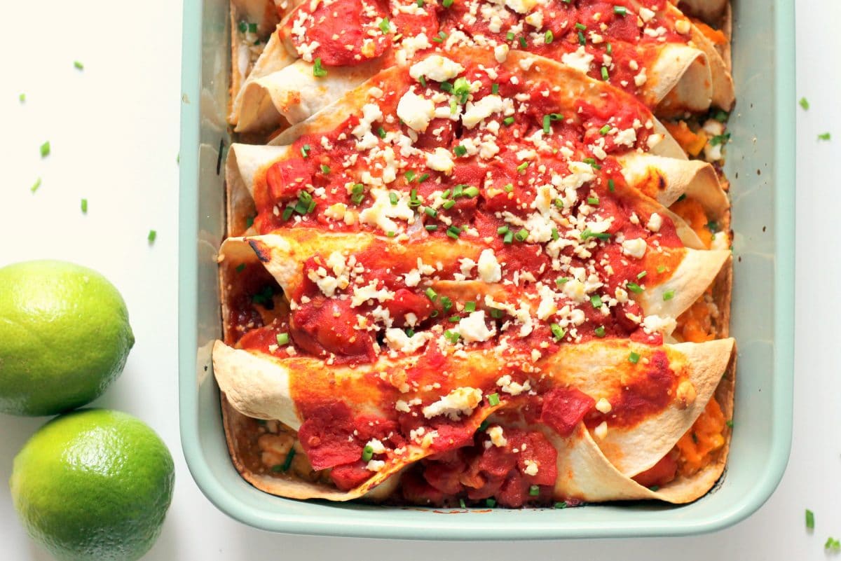 Sweet and smoky vegetarian enchiladas stuffed with baked sweet potatoes, feta cheese and corn. Served with a mild homemade tomato lime enchilada sauce, this dinner is healthy and simple to make. 