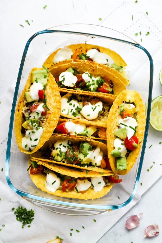 Oven baked tacos with salsa and sour cream toppings.