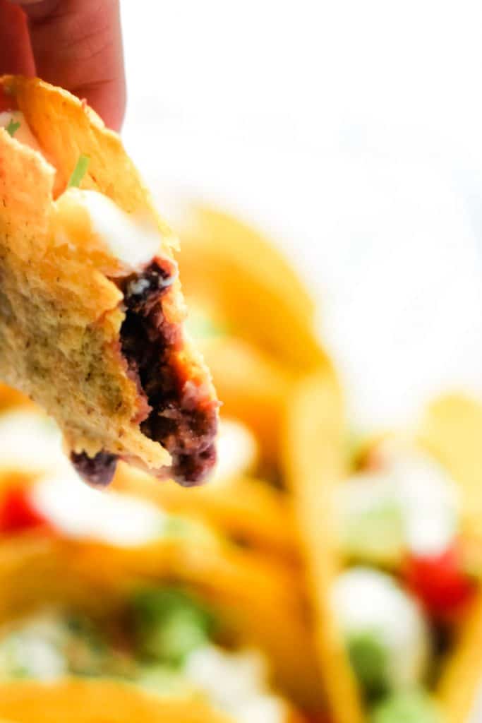 A simple 20 minute vegetarian taco dinner with black beans, smoked cheese and a fresh cherry tomato avocado salsa topping. Oven baked tacos are such a simple dinner, giving you extra crispy shells, melted cheese and a smoother workflow. Using smoked cheddar is an easy way to take classic bean and cheese tacos to the next level, making them completely irresistible! #tacos #vegetarianrecipes #easydinners #meatlessmonday