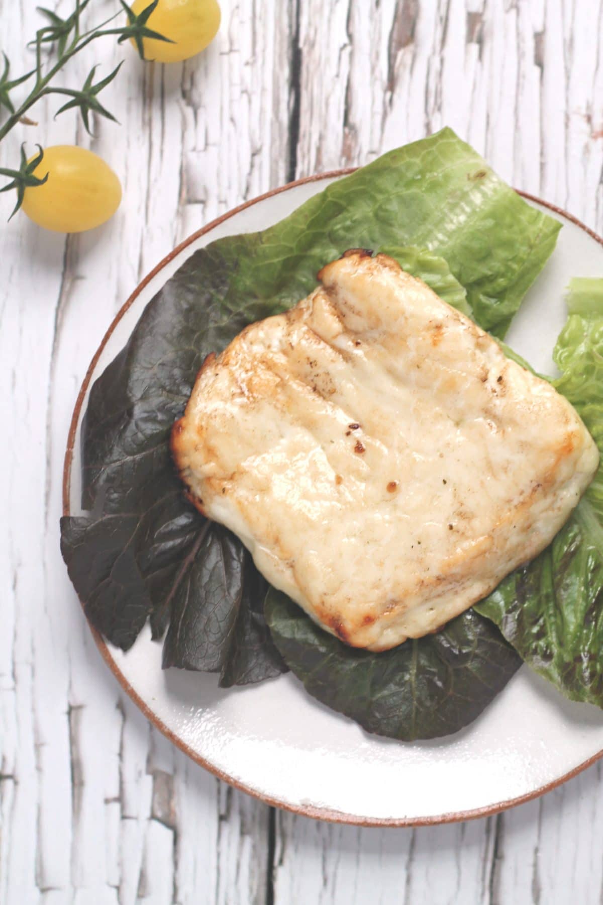 A slab of balsamic baked halloumi on a bed of lettuce leaves