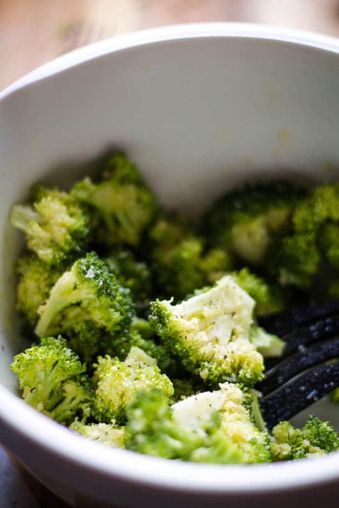 Raw broccoli with garlic being mixed in