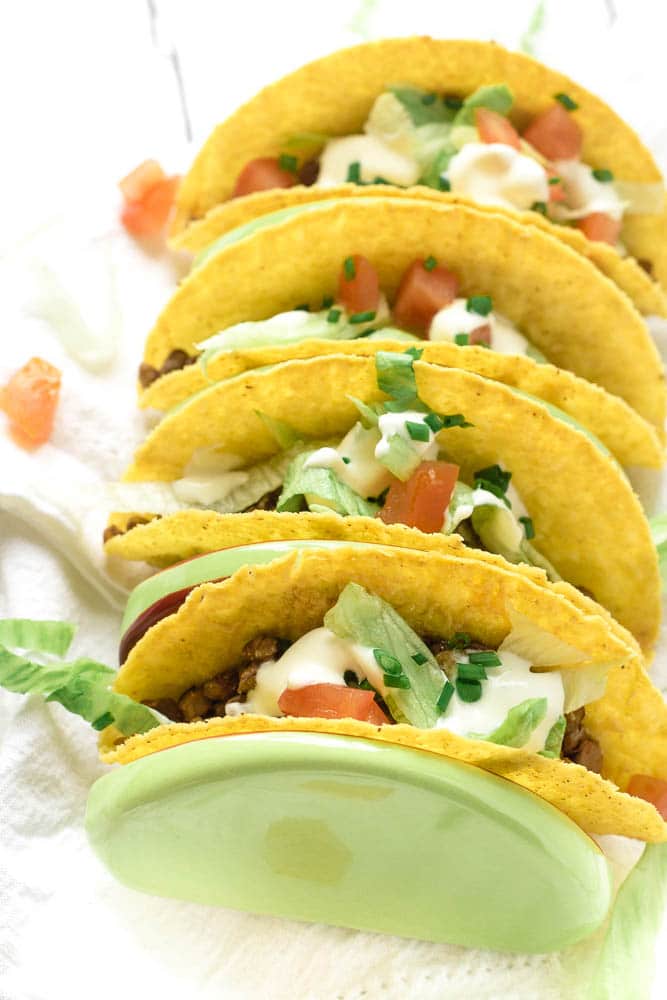 Four lentil tacos with toppings.