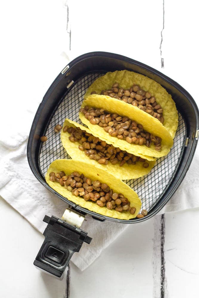 Tacos being prepared in an air fryer.