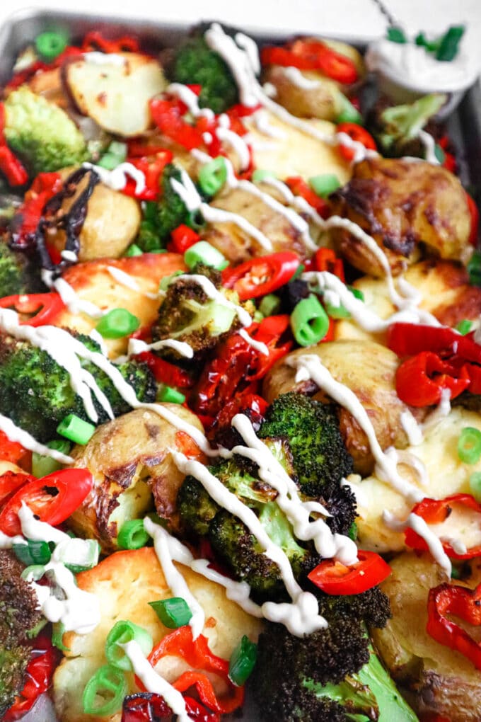 Finished halloumi, broccoli, potato tray bake after being drizzled in sauce.