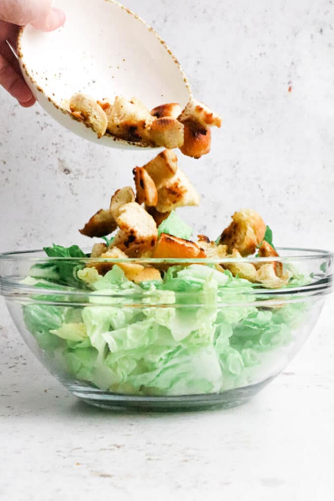 Croutons being added to salad