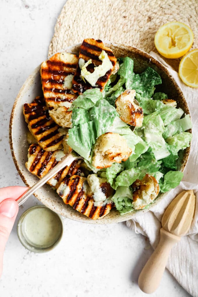 Top down shot of halloumi caesar salad with a fork