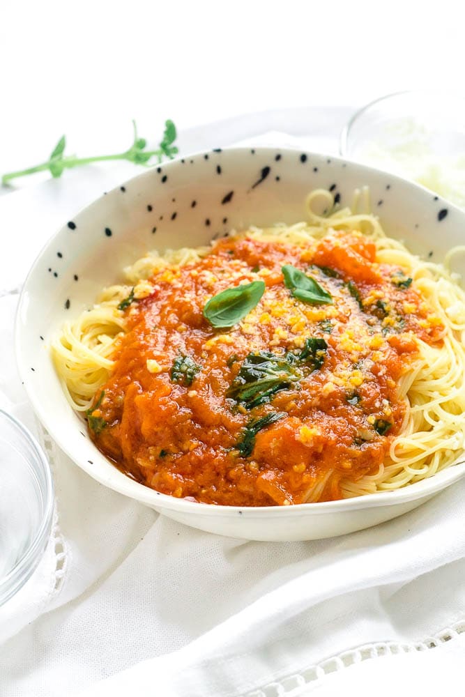 Bowl of angel hair pasta with tomato sauce topping