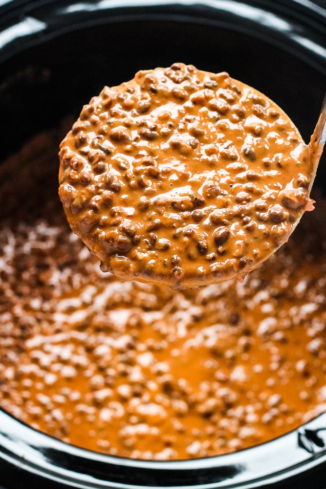 A spoonful of dishoom dal being lifted out of the slow cooker