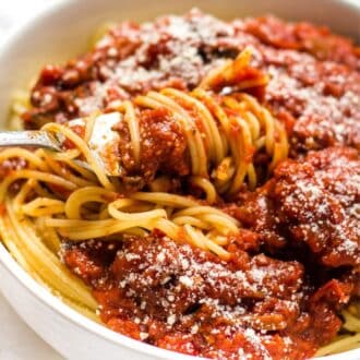 A close up of spaghetti sauce being twirled on a fork