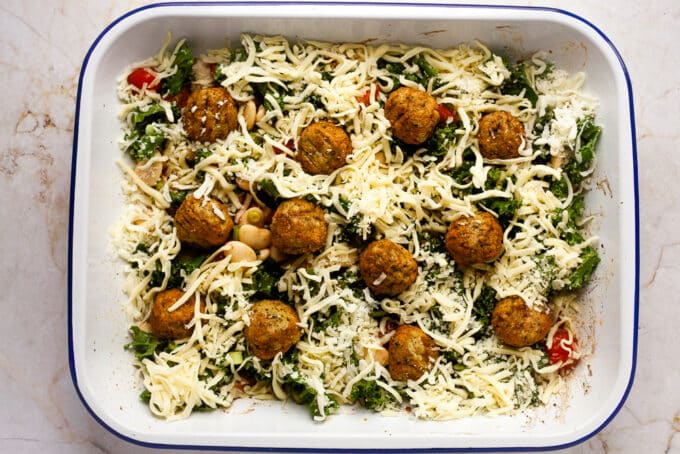 Falafel bake fully assembled with cheese and falafel balls on top