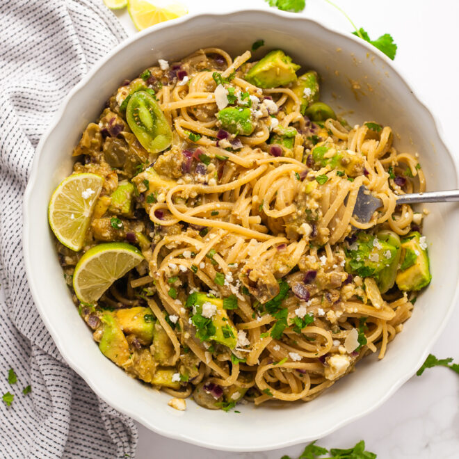 A close-up view of Southwestern Pasta with sliced green tomatoes and creamy avocado chunks